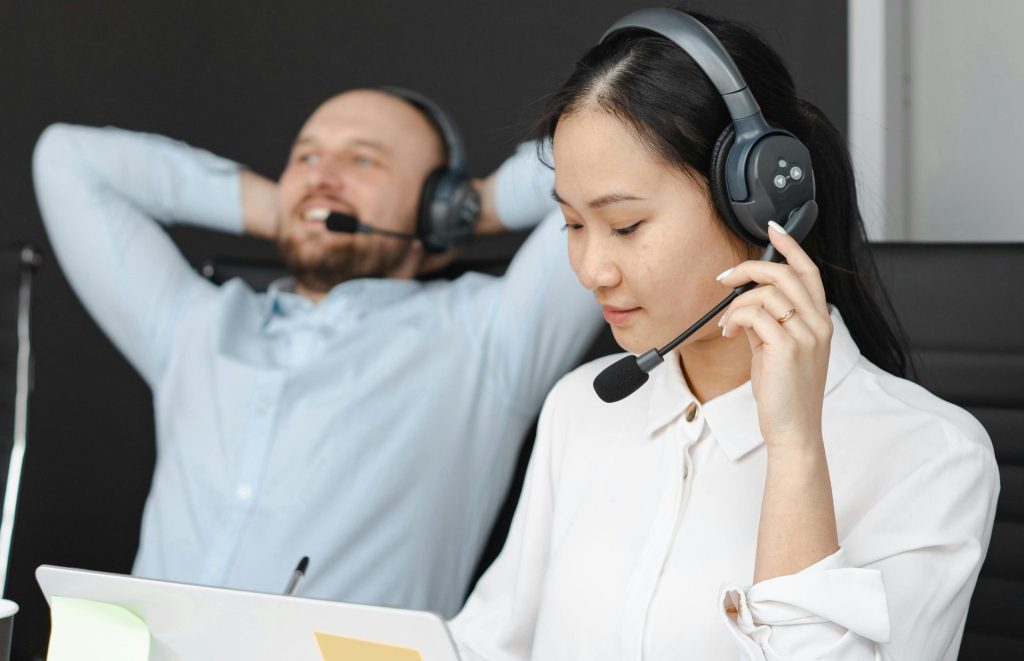 Close-up of customer service representatives with headsets working in an office.
